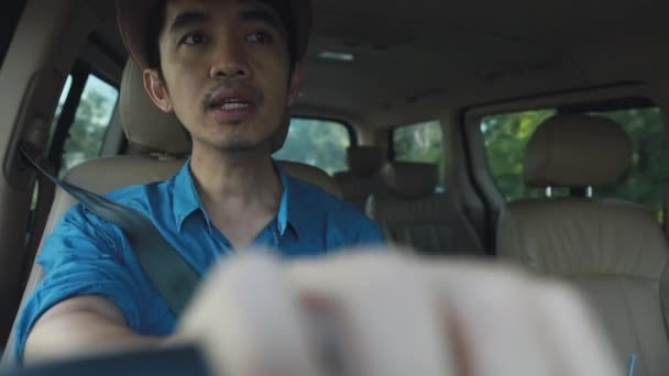 Средний снимок счастливого азиата за рулём машины и поющего песню
 - Кадры, видео