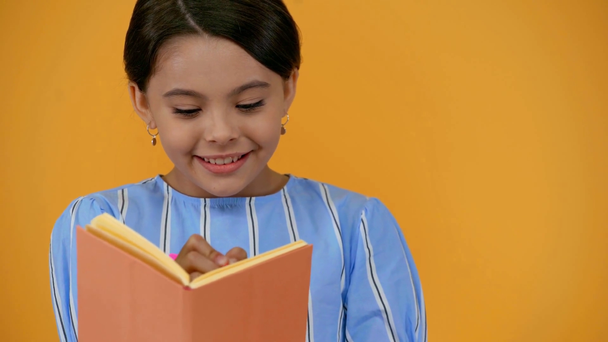 happy dreamy preteen child in blue dress writing in notebook - Footage, Video
