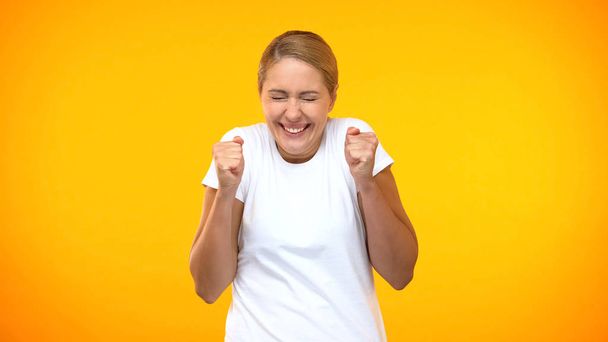 Excited woman rejoicing good news on bright background, amazement, success - Photo, image