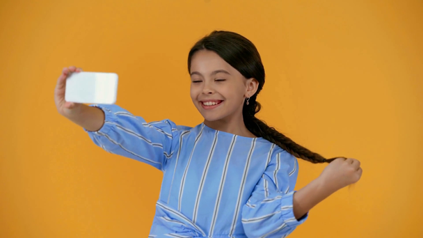 ευτυχισμένο Προεφηβικό παιδί σε μπλε φόρεμα λήψη selfie στο smartphone - Πλάνα, βίντεο