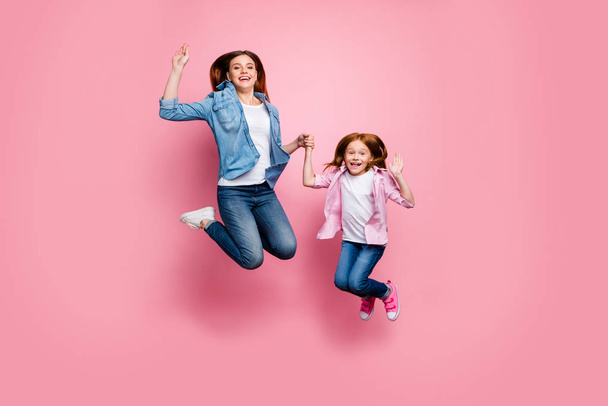 Full size photo of foxy little lady and her excited mom jumping high wear casual clothes isolated pink background - Zdjęcie, obraz