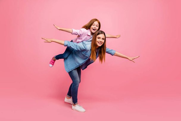 Funny foxy little lady and her mom ready for flight wear casual clothes isolated pink background - Foto, afbeelding