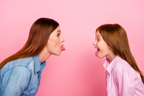 Pretty foxy little lady and her mom making silly facial expressions wear casual jeans clothes isolated pink background - Photo, image