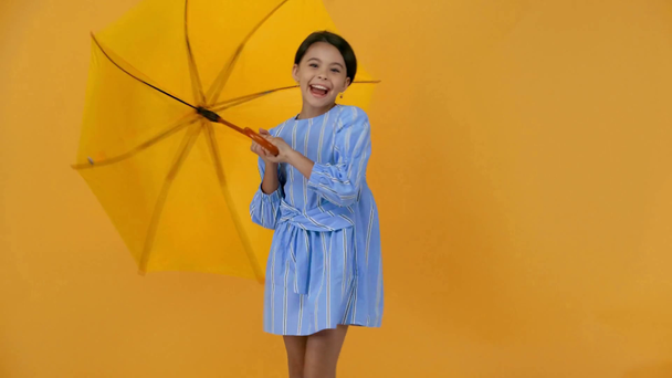 Gelukkig Preteen kind in blauwe jurk met gele paraplu - Video