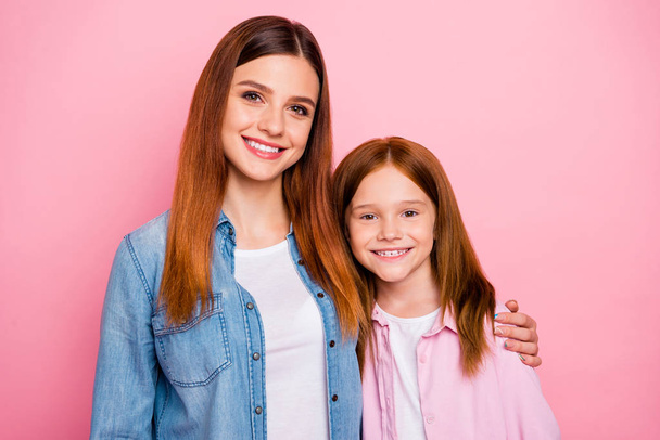 Portrait of two sweet girls hugging with toothy smile isolated over pink background - Foto, Imagem