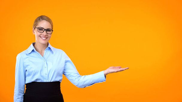 Smiling company worker pointing template orange background, business training - Foto, immagini