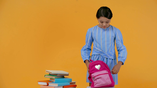 Gelukkig schoolmeisje zetten boeken in rugzak en lopen weg - Video