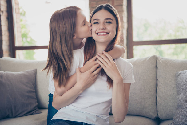 Portrait of lovely people having foxy ginger hair cuddling kissing smiling wearing white t-shirt sitting divan in house indoors - Фото, изображение