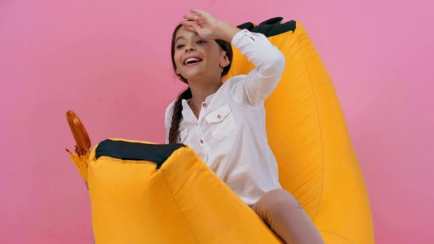 ピンクに隔離された傘を持つ幸せな子供の漕ぎ偽のボート - 映像、動画