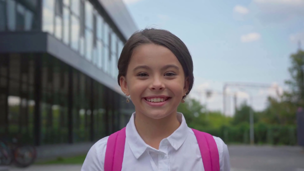 boldog iskolás tisztelegve és a gyaloglás az iskolaudvaron - Felvétel, videó