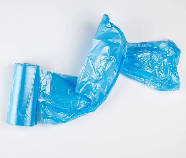 sacos de plástico azul torcido para bin no fundo branco
 - Foto, Imagem