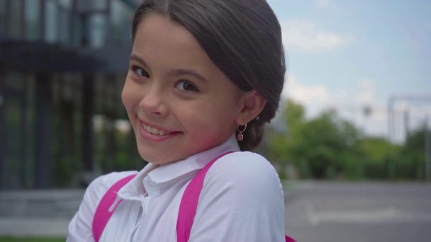szczęśliwy nieśmiały uczennica z plecak w szkolnym - Materiał filmowy, wideo