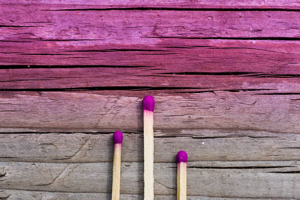 Three matches on a multicolored wooden background. Space for let - 写真・画像