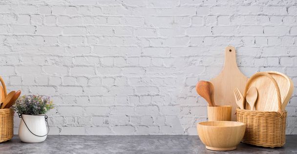 utensílios de cozinha de madeira e vaso de flores na parede de tijolo branco textura ba
 - Foto, Imagem