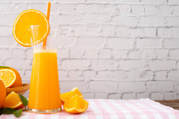 kitchen table with jug of orange juice on white brick wall textu - Photo, Image