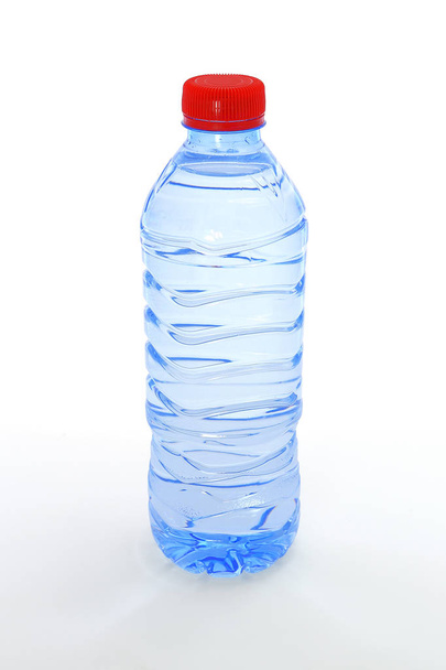 Полная пластиковая бутылка минеральной воды с красной крышкой изолированный фон
 - Фото, изображение