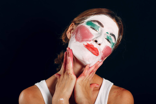 junge Frau schminkt sich, schminkt Gesicht mit Pinsel und genießt das Ergebnis. Wie man kein Make-up-Konzept macht. - Foto, Bild