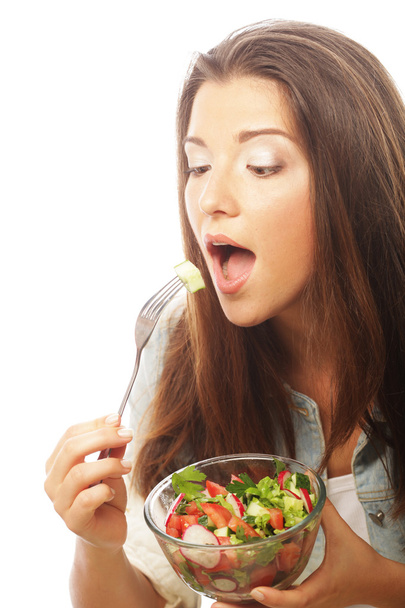 Młoda szczęśliwa kobieta jedzenie sałatka. - Zdjęcie, obraz