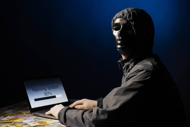 Anonimowe hacker programista używa laptopa do hack system w ciemności. Tworzenie i infekcji złośliwego wirusa. Pojęcie bazy danych cyberprzestępczości i hacking - Zdjęcie, obraz
