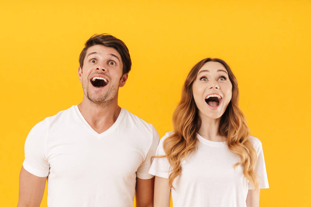 Portrait of delighted couple man and woman in basic t-shirts won - Foto, immagini