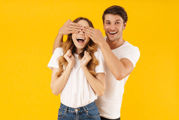 Photo of happy man smiling and covering woman's eyes standing be - Foto, Bild