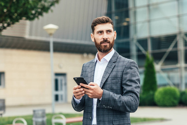 Handsome man In suit using smartphone - Photo, Image