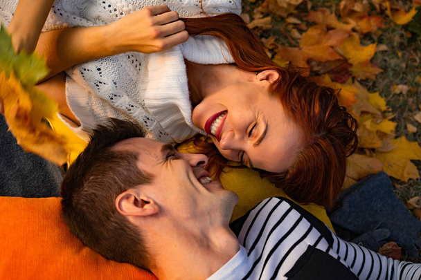 young couple in love. Lovers man and woman in the park in autumn, tenderness, hugs and kisses, happy couple. - Фото, изображение