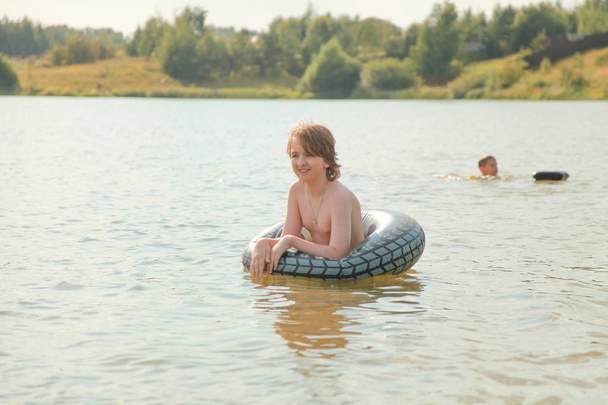 Cute Little Boy zabawy grając z nadmuchiwane pierścień pływać w gorący letni dzień. - Zdjęcie, obraz