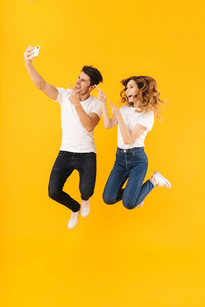 Full length portrait of cheerful couple man and woman in basic t - Photo, Image