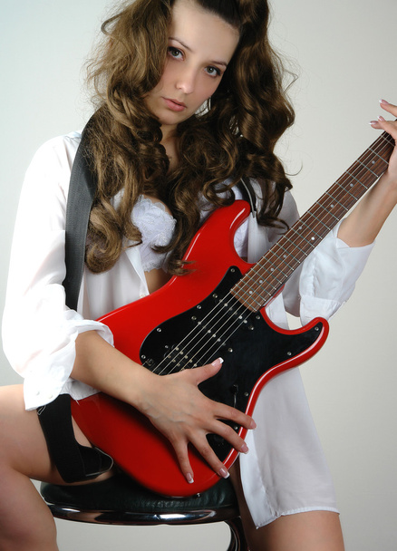 Woman in men shirt with red guitar - Фото, изображение