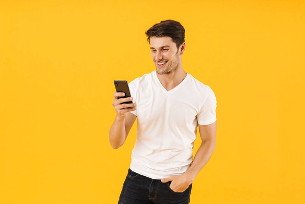 Foto di giovane uomo in t-shirt di base sorridente alla macchina fotografica mentre tiene
 - Foto, immagini