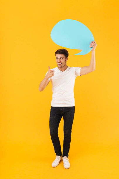 Photo of positive man in basic t-shirt showing thumb up and hold - Fotoğraf, Görsel