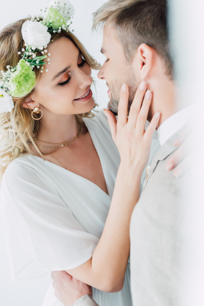 attractive bride and handsome bridegroom hugging and kissing with closed eyes  - Foto, imagen