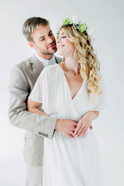 attractive bride and handsome bridegroom hugging and looking at each other  - Fotografie, Obrázek