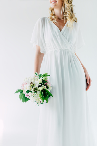 cropped view of bride in wedding dress holding bouquet isolated on white - Foto, Imagem