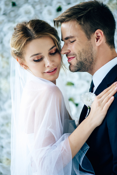 ελκυστική νύφη και όμορφος γαμπρός Αγκαλιάζοντας με κλειστά μάτια  - Φωτογραφία, εικόνα