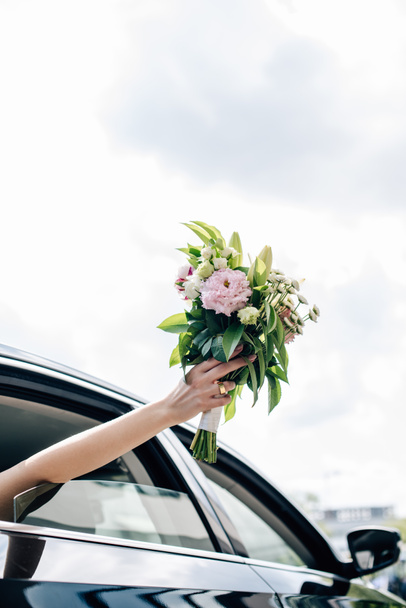 cropped view of young adult bride holding holding bouquet - Valokuva, kuva