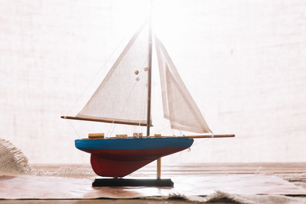 navire décoratif avec voile blanche à la surface avec hessian
 - Photo, image