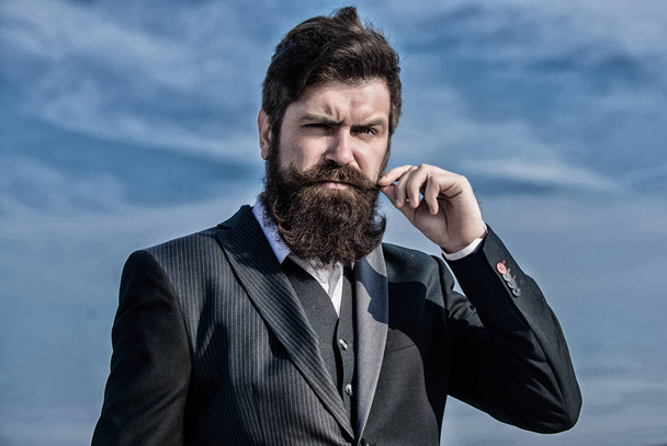 Businessman against the sky. Bearded man. brutal caucasian hipster with moustache. Future success. Male formal fashion. Mature hipster with beard. Bearded man touch beard. Man with beard outdoor - Φωτογραφία, εικόνα