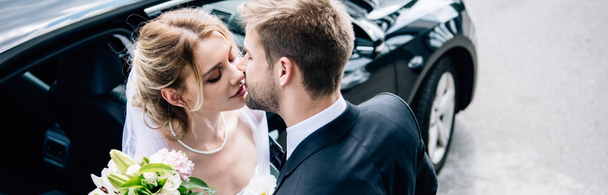 plano panorámico de novia atractiva y guapo novio besándose fuera
  - Foto, imagen