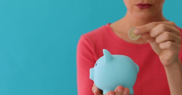 Uśmiechnięta kobieta przewożąca Piggy Bank - Materiał filmowy, wideo