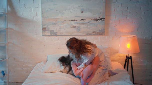 μητέρα και κόρη χορεύουν στο κρεβάτι τη νύχτα - Πλάνα, βίντεο