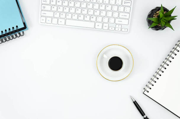 Клавіатура та блокнот з ручкою, чашка кави на білому офісному столі. Дизайнерське робоче місце плоский макет
 - Фото, зображення