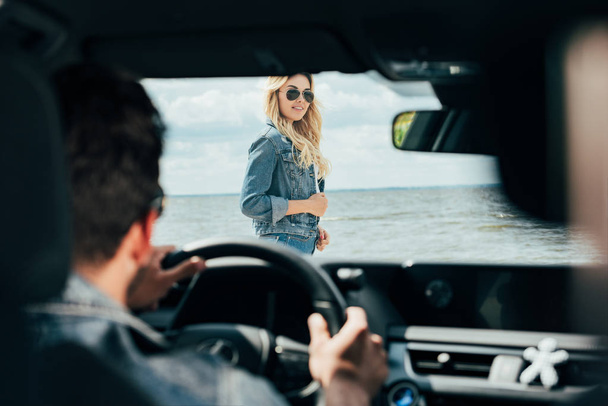 selective focus of attractive woman in denim jacket looking at man  - Photo, image
