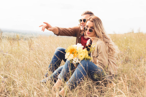 attractive woman with bouquet and handsome man pointing with finger  - Fotoğraf, Görsel