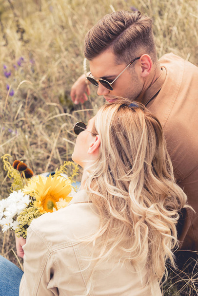 high angle view of woman with bouquet and handsome man hugging outside  - Photo, image