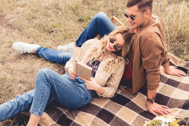 attractive woman and handsome man smiling and reading book  - Fotoğraf, Görsel