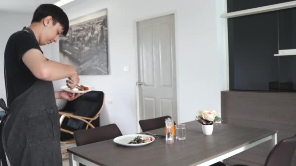 Jong gemengd ras duizendjarige man bereidt een smakelijk en gezond ontbijt in zijn appartement, lifestyle concept   - Video