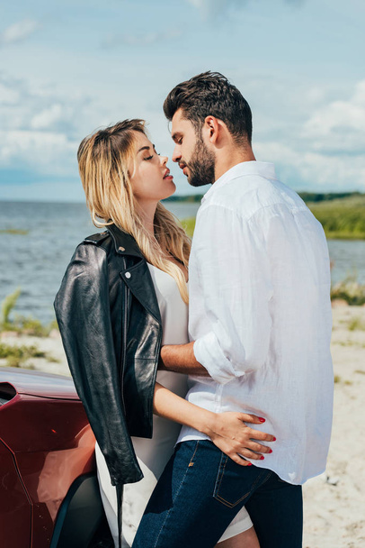 attractive woman and handsome man hugging and kissing outside  - Фото, зображення