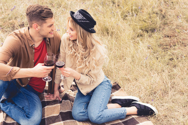 knappe man en aantrekkelijke vrouw geproost met wijn glazen - Foto, afbeelding